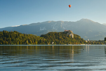 Landscape of Lake Bled on an autumn morning. In the background, the Alps and a flying balloon.