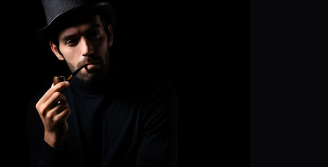 Detective or Spy man smoking pipe Portrait handsome young bearded guy wear top hat smoking a pipe He looking away and thinking planning something in the dark room retro style and retro fashion concept