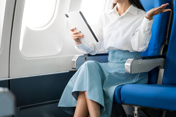 travel and technology Fly in first class Beautiful Asian businesswoman working using laptop computer while sitting on airplane
