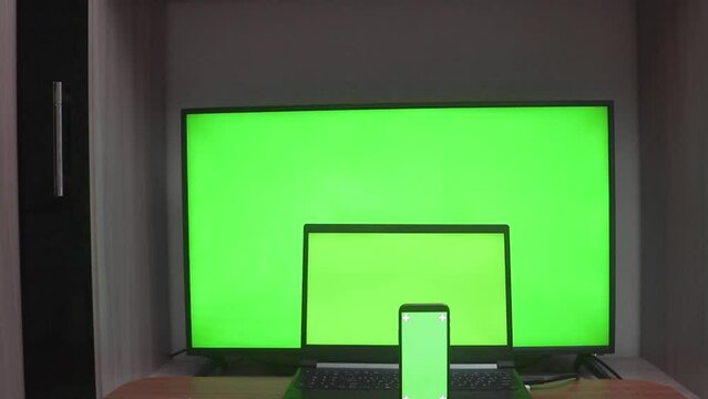 Laptop, mobile phone and HDTV with chromakey screens, with copy space. Green screen concept for product presentation, online orders