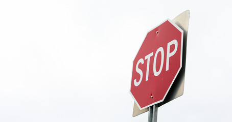 red stop sign on urban street corner, symbolizing road safety and traffic regulations. Clear blue...