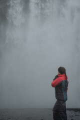 Obraz premium Girl standing in a glacial waterfall in Iceland