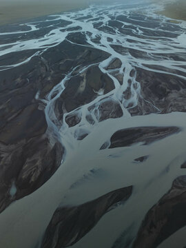 Silhouette of glacial rivers in Iceland from a drone view that look like an aquarelle
