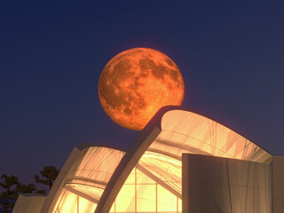 Red full moon rising on modern building on dark sky background (3d rendering)
