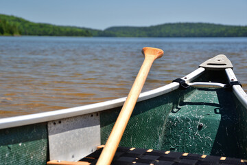 Green canoe with paddle ready for adventure on a fresh water lake