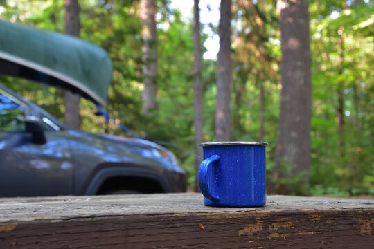 Blue emanel coffe cup in nature. Morning preparation for canoe padling day. Relax moment before active day