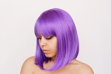 Young woman with the dyed deep purple hair isolated on white background. Result of coloring. Bright saturated extravagant color. Beauty and fashion. Colored bright wig with square and bangs