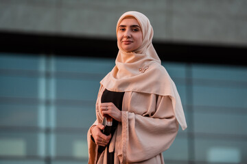 Portrait of a confident Muslim business woman in hijab near the modern office building.