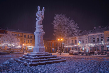 Pomnik Św. Floriana na rynku W Brzesku zimą w nocy | Monument of the St. Florian on the town square in Brzesko by winter by night - obrazy, fototapety, plakaty