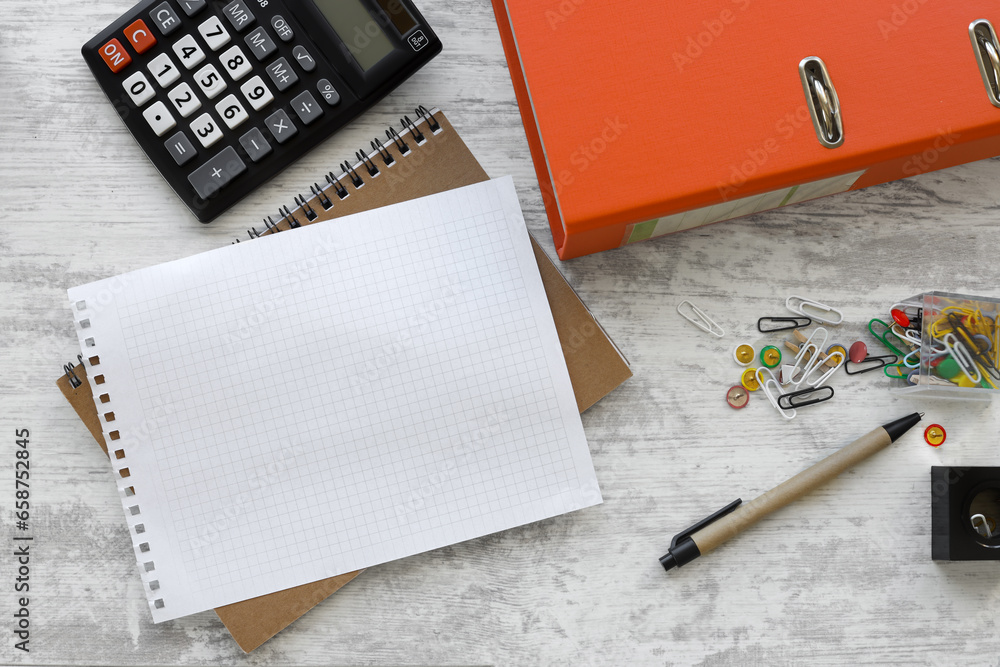 Poster design concept - top view of spiral notebook and orange folder isolated on wooden background for moc