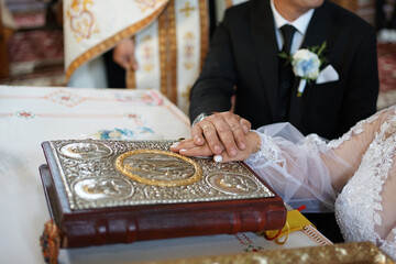During a church wedding, newlyweds rely on the Gospel. Wedding ceremony in the church.