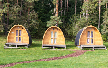 Wood camp rental cabins near green fir forest. Small log houses for vacation. Summer camping....