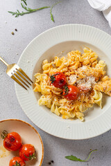 italian pasta with sauce and grilled tomato served with parmesan and arugula close up