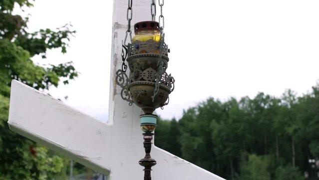Icon-lamp on wooden cross near the Orthodox Temple