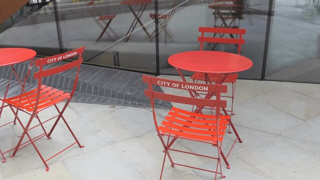 Orange tables and chairs outdoors in the City of London.
