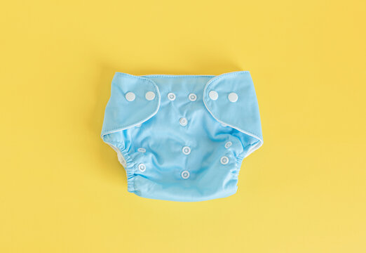 Flat lay with reusable cloth baby diapers. Eco friendly nappies on pastel background. Sustainable lifestyle, zero waste idea