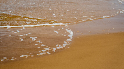 Soft sea wave on the sandy beach. Baltic Sea coast, Latvia