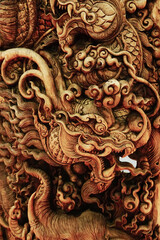 A wood carved dragon, Traditional Chinese style Dragon Abstract with Low Relief Technique. Wooden wall for abstract background patterns, vertical,close up, selective focus.