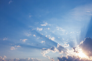  Sunrise with sun rays sunlight  in  clouds against bright blue sky