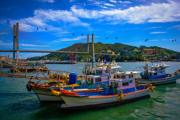 Fishing trawlers moored under Dolsan Bridge harbor under the cable cars station in Yeosu City,...