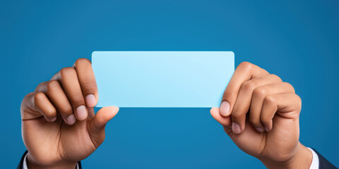 man's hands holding blank sheet mock up on a blue background