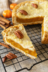 Fall traditional pie pumpkin with crumble and pecan on a gray stone background. Thanksgiving dessert.