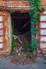 Entrance to an old ruined and burned building with a brick wall