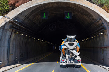Concrete mixer truck entering a highway tunnel.