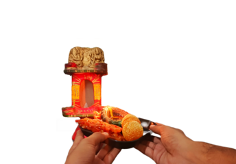 On diwali, doing lakshmi pooja with diya and other indian sweets. Happy diwali template for businesses showing puja ritual with decoration in background and holding puja thali having earthen lamp.