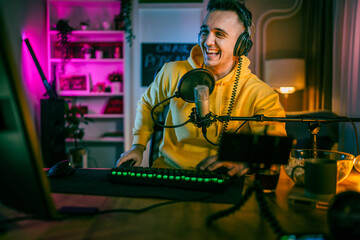 Young man male gamer playing computer game streaming video online