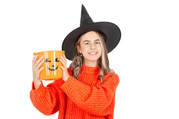 Halloween celebration concept. Portrait of smiling girl in black hat, with pumpkin jack for sweet...