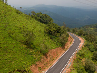 Drone view of savage road in the middle of the forest and mountains
