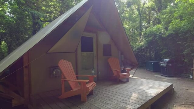 Point Pelee camping site with cabin tent under canopy of the Carolinian Forest in the park. Accommodation shelter for tourists and visitors during vacation. Site with barbeque fire pit. Campground.