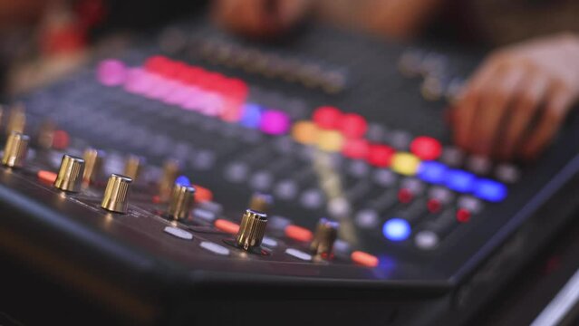 View of lighting technician operator working on mixing console workplace during live conference event, concert show broadcast, light mixer controller panel, workplace sound professional equipment
