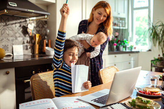 Young boy showing his online teacher the correct math equation at home - Powered by Adobe