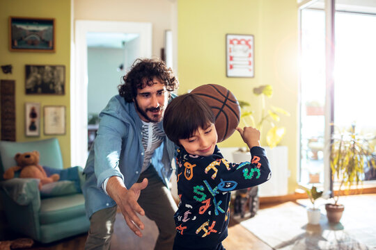 Young father and son having fun with a basketball at home