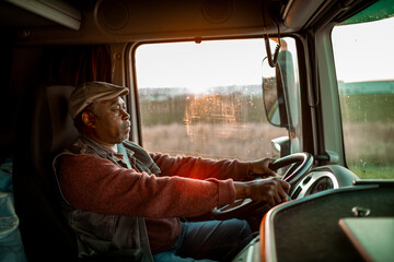 Senior African American truck driver driving a shipment on the highway
