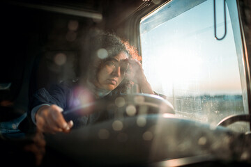 Young female truck driver is getting tired after a long driving session