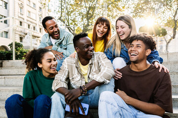 Young group of student friends having fun relaxing together outdoors. Millennial college people sitting together on urban stairs enjoying conversation. Digital detox and youth community concept. - obrazy, fototapety, plakaty