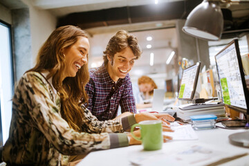 Young group of coworkers going over paperwork in the office of a startup company
