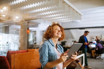 Young Caucasian woman using a tablet in the office of a startup company