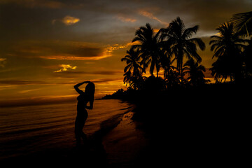 A Nude Latin Model Poses Against The Colorful Sky As The Sun Rises On The Pacific Ocean In Baja California