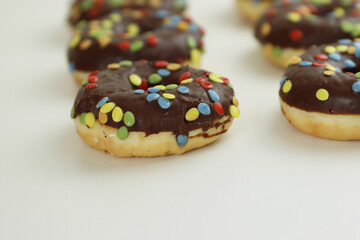 Set of Brown chocolate donut decorated with smarties isolated on white background side view. Fried dough confection, dessert food, sweet snack with chocolate glazing and candies. Selective focus