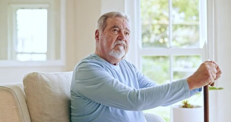 Senior man, walking stick and thinking in home or living room with nostalgia, memory or decision in retirement. Elderly, dementia and old person with alzheimer remember past or history in house