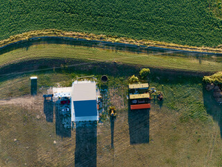 Drone shot of farmhouse and surrounding fertile green fields, tidy and neat. 