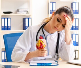 Young female doctor cardiologist sitting at the hospital