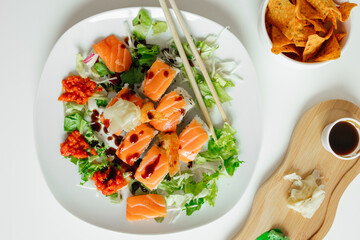Top view of fusion salmon sushi rolls with sauce on white plate. Healthy and fusion japanese food style concept