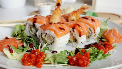 Traditional Japanese food. close-up. Sushi decorated with teriyaki sauce. Freshly cooked sushi rolls, served on a white plate at home