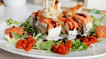Traditional Japanese food. close-up. Sushi decorated with teriyaki sauce. Freshly cooked sushi rolls, served on a white plate at home