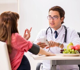 Pregnant woman visiting doctor discussing healthy diet